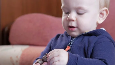 An attractive boy 2 years old he molds himself from a multi-colored plasticine Stock Footage 73963395