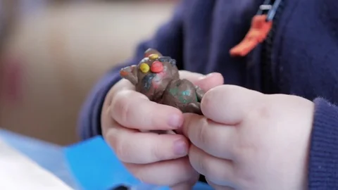 An attractive boy 2 years old he molds himself from a multi-colored plasticine Stock Footage 73963523