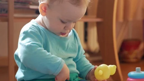 Attractive boy 2 years of playing at home with a plastic duck. The kid talks to Stock Footage 74712116