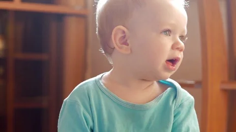 Attractive boy 2 years of playing at home with a plastic duck. The kid talks to Stock Footage 74712577