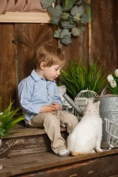 Attractive boy playing with Easter bunny in a green grass Stock-Fotos