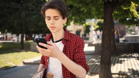 Attractive boy using a mobile phone smile walk keeps skate guy business fashion Stock Footage 92051014