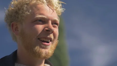 An attractive boyish blond millennial with a beard smiling and laughing Stock Footage 72363866
