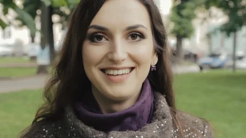Attractive Brunette with Charming Smile Posing Outdoors and Looking at the Видео 77235993