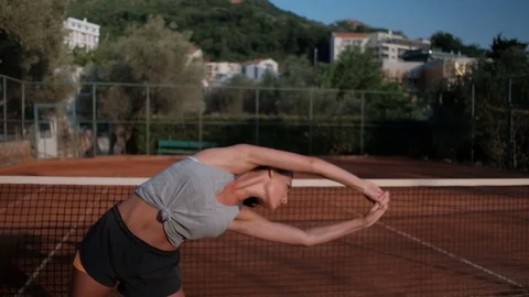Attractive brunette doing lateral bends exercise standing in stadium on summer Stock Footage 81166938