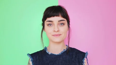 Attractive brunette eats macarons isolated on bright backgrounds Stock Footage 73295446