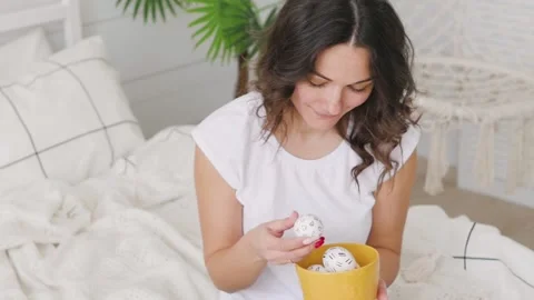 Attractive brunette girl with easter eggs in her hands smiling. 库存影片 131596473
