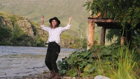 Attractive brunette in a hat and a white shirt in peas enjoys nature in the Stock Footage 131139213