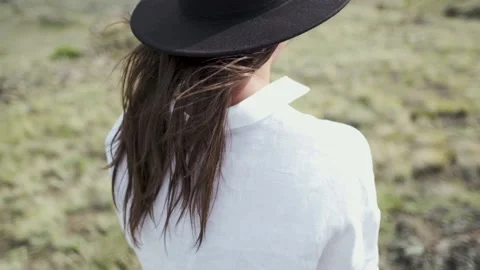 Attractive brunette in a hat and white shirt is enjoying nature in the mountains Видео 131281765