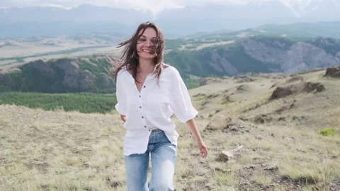 Attractive brunette in a hat and white shirt is enjoying nature in the mountains Stock Footage 131430746