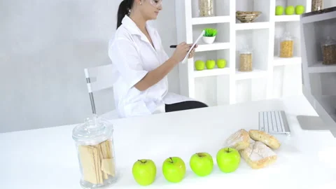 Attractive brunette lab technician working with technology in the study of nutri Vídeo Stock 199629262