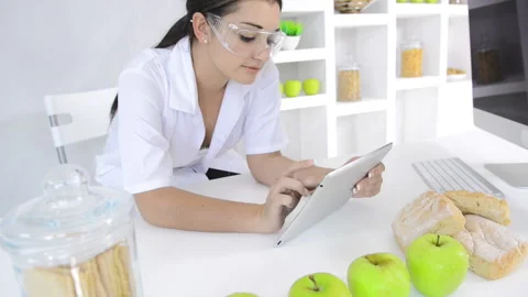 Attractive brunette lab technician working with technology in the study of nutri Vídeo Stock 199629279