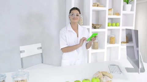 Attractive brunette lab technician working with technology in the study of nutri Stock Footage 199629280