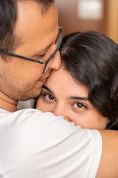 Attractive brunette looking at camera while hugging her boyfriend Stock Photos