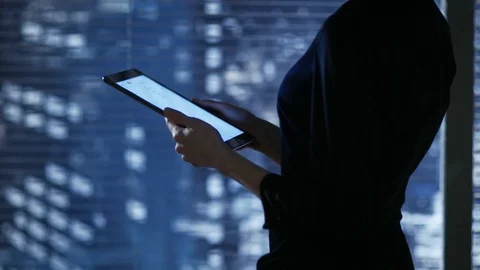 Attractive Brunette Uses Tablet Computer while Standing Near the Window. Stock Footage 75217218