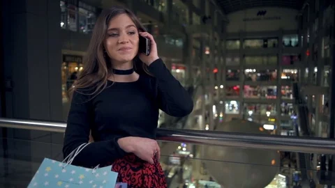 Attractive brunette woman talking on the phone in the mall slow motion Stock Footage