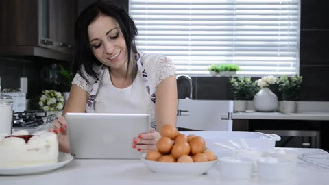 Attractive brunette woman using tablet computer while backing Stock-Footage 199628923