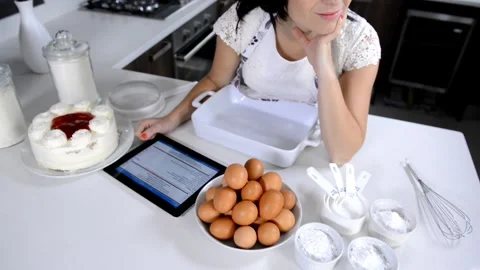 Attractive brunette woman using tablet computer while backing 스톡 동영상 199628929