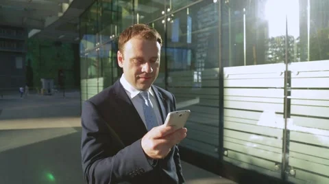 Attractive business man using app on smart phone walking in city Stock-Footage 68385332