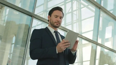 Attractive business man using tablet device, surfing internet, reading, textin 動画素材 76624286