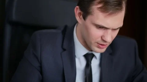 Attractive business man working with a computer and documents in the office Video stock 74017579