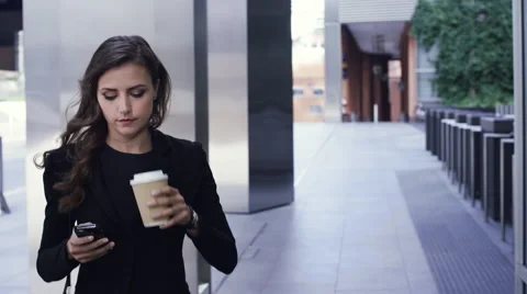Attractive business woman commuter using smartphone walking in city of london Stock Footage