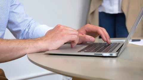 Attractive businessman looking at a graph while using his laptop in office Stock Footage 93535800