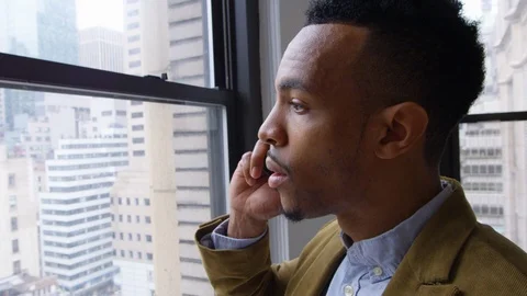Attractive businessman looking through window while talking on the phone Stock Footage 93530226