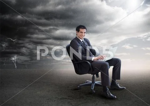 Attractive businessman using his laptop outside during stormy weather Stock Photos