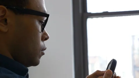 Attractive businessman using his mobile phone in the office 스톡 동영상 93537703