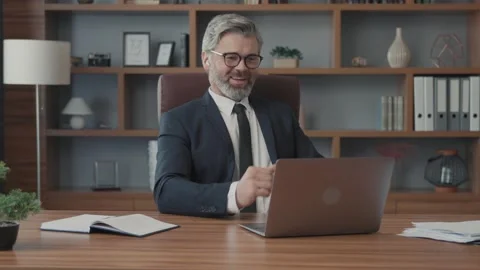 Attractive businessman using a laptop talking to a camera making a conference Vídeos de archivo 220189186