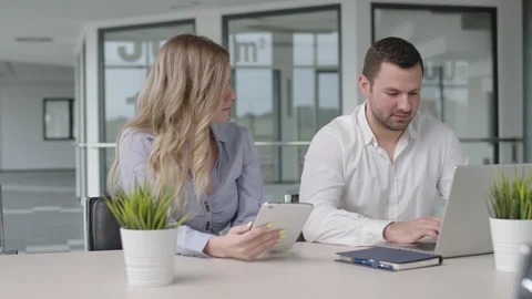 Attractive businesswoman shows something funny on tablet to a colleague Stock Footage