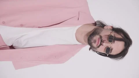 Attractive casual man with retro rectangular sunglasses holding hands in pockets 库存影片 272576070