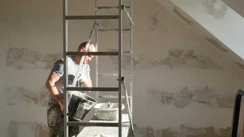 Attractive caucasian man making plaster for house renovation construction. Stock Footage 147515035