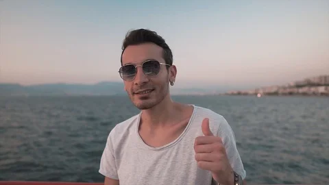 Attractive charismatic young guy thumbs up with beautiful sun light.  Stock Footage 112935189