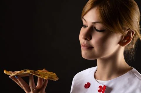 Attractive chef looking slice of pizza Stock Photos