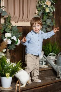 Attractive child playing with Easter bunny in a green grass Foto stock