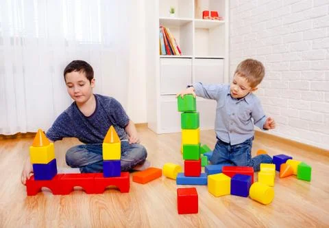 Attractive children playing with constructor on floor at home Fotos de archivo