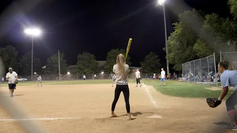 Attractive coed batter sprints around 1st on to 2nd-framed by fence Stock Footage 112893530