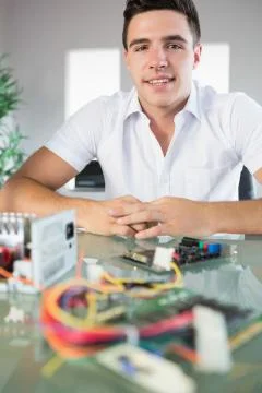 Attractive computer engineer sitting at desk looking at camera Stock Photos