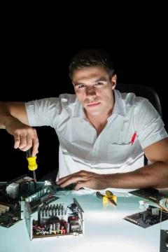 Attractive computer engineer working by night with screw driver Stock Photos