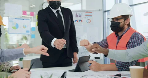 Attractive confident experienced diverse team in protective masks joining their Stock Footage 145799956