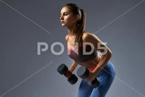 Attractive confident fitness girl pumping up muscles biceps Stock Photos