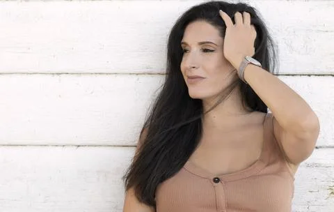 Attractive, confident Middle Eastern looking woman leaning on a white wall Stock Photos