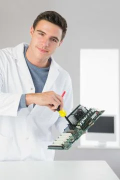 Attractive content computer engineer repairing hardware with screw driver Stock Photos