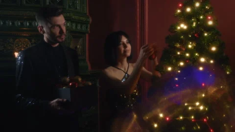 Attractive couple is decorating Christmas tree for New Year's party at home Stock Footage 161677195