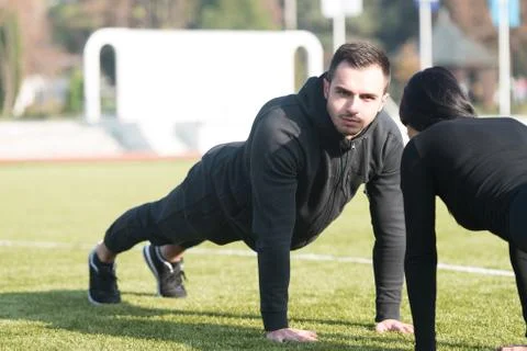 Attractive Couple Doing Pushups in the Park Stock Photos