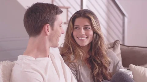 Attractive couple having a conversation while relaxing in their living room Stock Footage 83000953