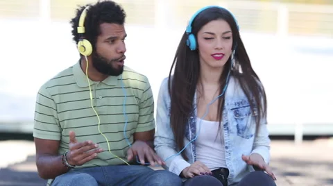 Attractive couple having fun listening to music with headphones Stock Footage 59555545