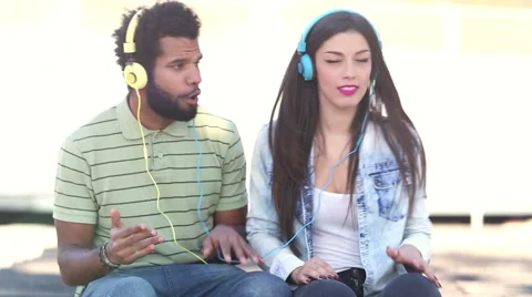 Attractive couple having fun listening to music with headphones Stock Footage 59555553